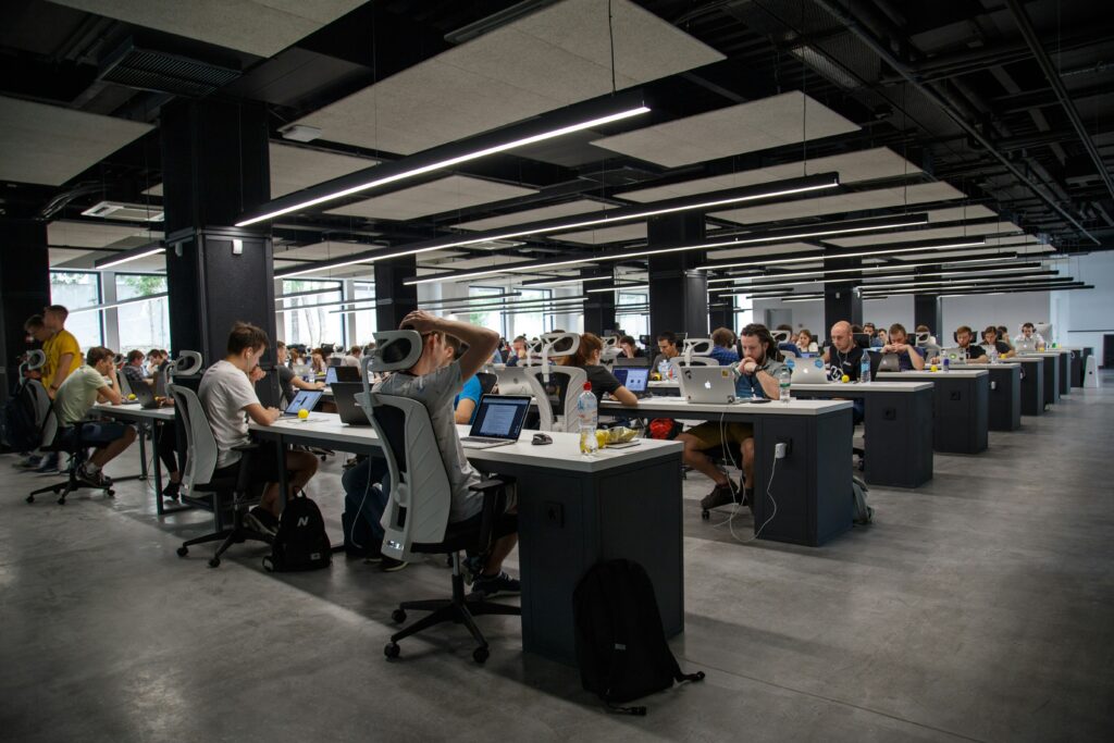 Open office space with dozen of people working at their desks.